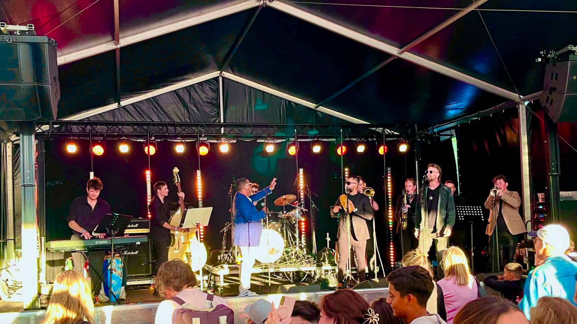 JL Son de Armonía on a festival stage with a full horn section and a packed crowd