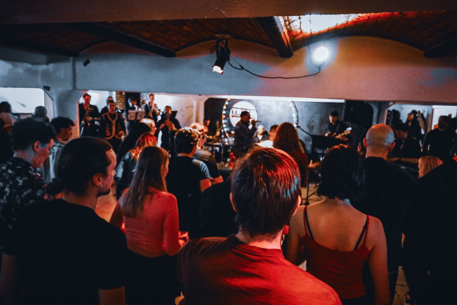 Packed room watching JL Son de Armonía play live under red light